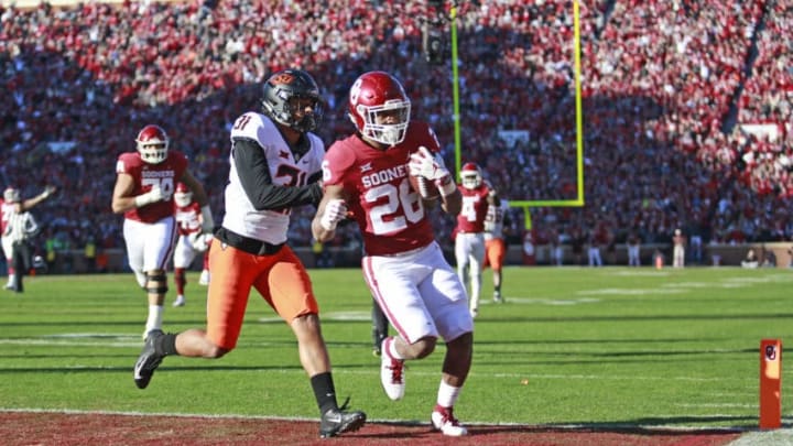 NORMAN, OK - NOVEMBER 10: Running back Kennedy Brooks #26 of the Oklahoma Sooners scores in front of safety Kolby Peel #31 of the Oklahoma State Cowboys at Gaylord Family Oklahoma Memorial Stadium on November 10, 2018 in Norman, Oklahoma. (Photo by Brett Deering/Getty Images)