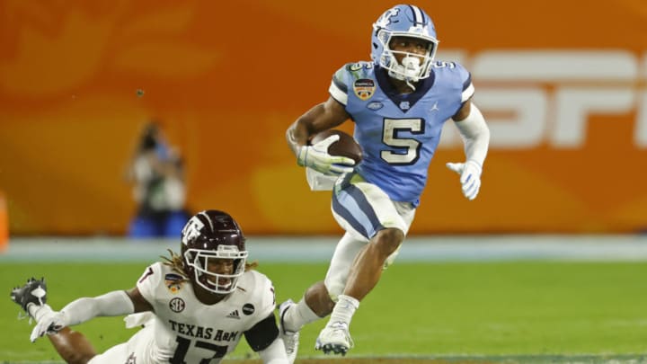 MIAMI GARDENS, FL - JANUARY 2: Dazz Newsome #5 of the North Carolina Tar Heels runs past the attempted tackle by Jaylon Jones #17 of the Texas A&M Aggies at the Capital One Orange Bowl at Hard Rock Stadium on January 2, 2021 in Miami Gardens, Florida. (Photo by Joel Auerbach/Getty Images)