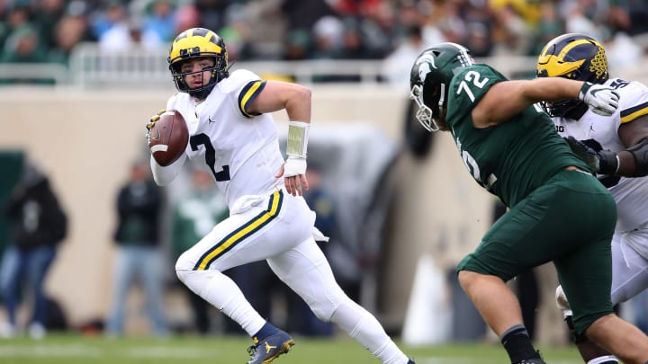 EAST LANSING, MI – OCTOBER 20: Shea Patterson #2 of the Michigan Wolverines looks for a open receiver while being chased by Mike Panasiuk #72 of the Michigan State Spartans during the second quarter at Spartan Stadium on October 20, 2018 in East Lansing, Michigan. (Photo by Gregory Shamus/Getty Images)