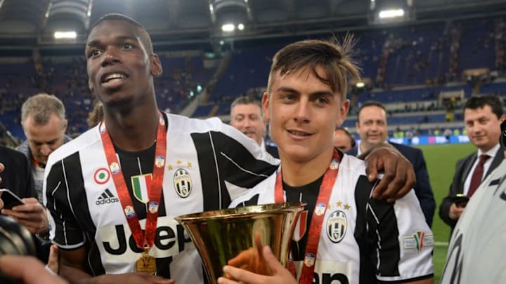 Juventus' forward from Argentina Paulo Dybala (R) and Juventus' midfielder from France Paul Pogba celebrate with the trophy after winning the Italian Tim Cup final football match AC Milan vs Juventus on May 21, 2016 at the Olympic Stadium in Rome. Juventus won 0-1 in the extra time. AFP PHOTO / FILIPPO MONTEFORTE / AFP / FILIPPO MONTEFORTE (Photo credit should read FILIPPO MONTEFORTE/AFP/Getty Images)