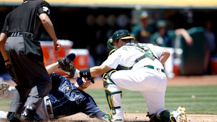 OAKLAND, CA - JUNE 23: Josh Phegley #19 of the Oakland Athletics tags Austin Meadows #17 of the Tampa Bay Rays out at home during the game at the Oakland-Alameda County Coliseum on June 23, 2019 in Oakland, California. The Rays defeated the Athletics 8-2. (Photo by Michael Zagaris/Oakland Athletics/Getty Images)