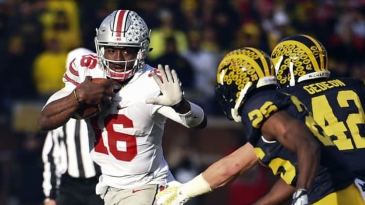 Nov 28, 2015; Ann Arbor, MI, USA; Ohio State Buckeyes quarterback J.T. Barrett (16) and a Michigan defender. Mandatory Credit: Tim Fuller-USA TODAY Sports.