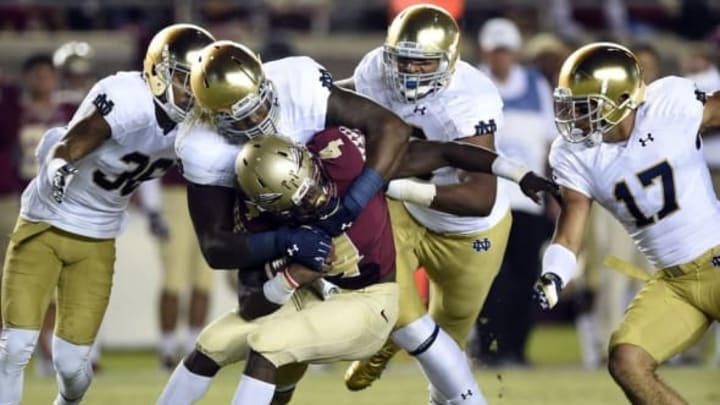 Oct 18, 2014; Tallahassee, FL, USA; Florida State Seminoles running back Dalvin Cook (4) gets wrapped up by Notre Dame Fighting Irish defensive lineman Jarron Jones (94) at the line during the first quarter at Doak Campbell Stadium. Mandatory Credit: John David Mercer-USA TODAY Sports