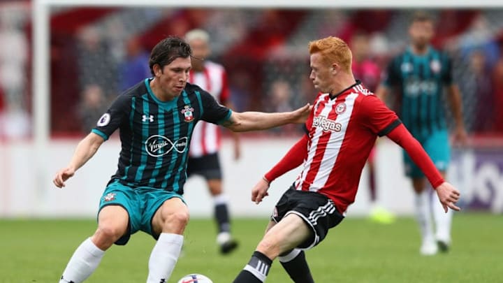 BRENTFORD, ENGLAND - JULY 22: Pierre-Emile Hojbjerg of Southampton is tackled by Ryan Woods of Brentford during the Pre Season Friendly match between Brentford and Southampton at Griffin Park on July 22, 2017 in Brentford, England. (Photo by Ian Walton/Getty Images)