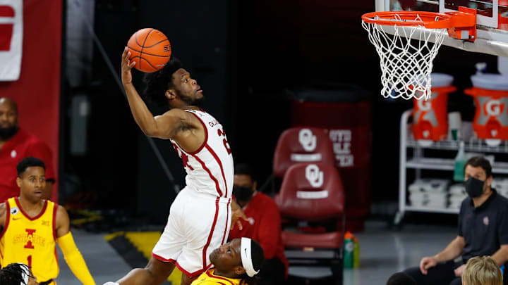 Feb 6, 2021; Norman, Oklahoma, USA; Oklahoma Sooners guard Elijah Harkless (24) goes up for a dunk over Iowa State Cyclones forward Solomon Young (33) during the second half at Lloyd Noble Center. Oklahoma won 79-72. Mandatory Credit: Alonzo Adams-USA TODAY Sports