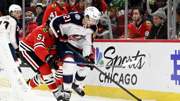 Dec 23, 2022; Chicago, Illinois, USA; Chicago Blackhawks defenseman Ian Mitchell (51) and Columbus Blue Jackets center Josh Dunne (21) move the puck during the first period at the United Center. Mandatory Credit: Matt Marton-USA TODAY Sports
