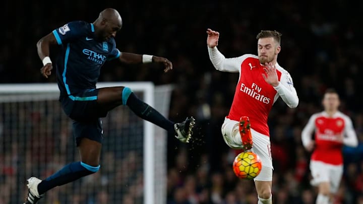 Manchester City's French defender Eliaquim Mangala (L) vies with Arsenal's Welsh midfielder Aaron Ramsey during the English Premier League football match between Arsenal and Manchester City at the Emirates Stadium in London on December 21, 2015. AFP PHOTO / IKIMAGESRESTRICTED TO EDITORIAL USE. No use with unauthorised audio, video, data, fixture lists, club/league logos or 'live' services. Online in-match use limited to 45 images, no video emulation. No use in betting, games or single club/league/player publications. / AFP / IKIMAGES / IKIMAGES (Photo credit should read IKIMAGES/AFP/Getty Images)