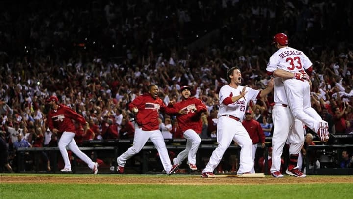 Oct 11, 2013; St. Louis, MO, USA; St. Louis Cardinals shortstop Daniel Descalso (33) celebrates with left fielder Matt Holliday (7) and third baseman David Freese (23) after scoring the winning run in the 13th inning against the Los Angeles Dodgers in game one of the National League Championship Series baseball game at Busch Stadium. Mandatory Credit: Jeff Curry-USA TODAY Sports