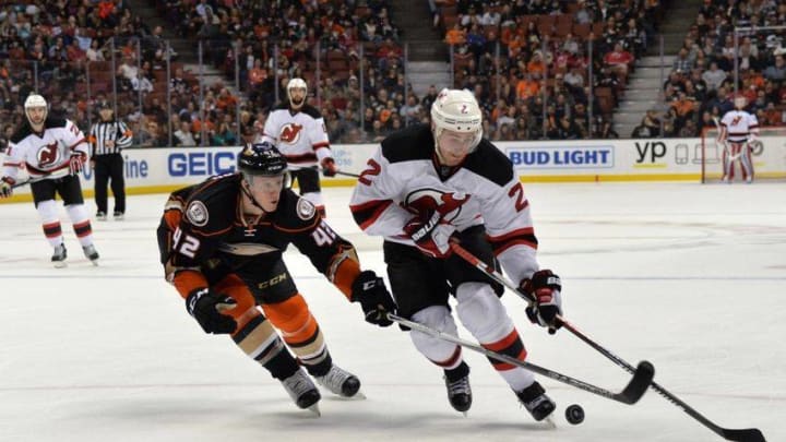 Mar 14, 2016; Anaheim, CA, USA; New Jersey Devils defenseman John Moore (2) and Anaheim Ducks defenseman Josh Manson (42) battle for the puck in the second period during an NHL game at Honda Center. Mandatory Credit: Kirby Lee-USA TODAY Sports