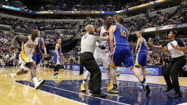 Feb 26 2013; Indianapolis, IN, USA; Officials try to separate a fight between Indiana Pacers center Roy Hibbert (55) and Golden State Warriors center David Lee (10) at Bankers Life Fieldhouse. Mandatory Credit: Brian Spurlock-USA TODAY Sports