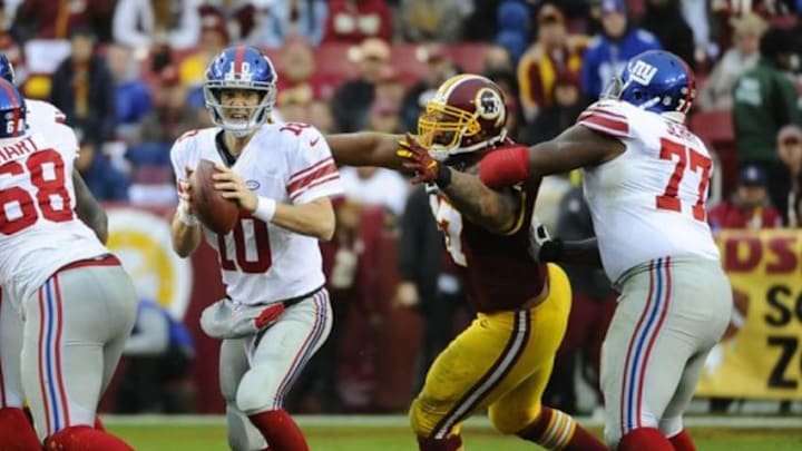 Nov 29, 2015; Landover, MD, USA; New York Giants quarterback Eli Manning (10) attempts to throw the ball as Washington Redskins defensive end Jason Hatcher (97) defends during the second half at FedEx Field. The Redskins won 20-14. Mandatory Credit: Brad Mills-USA TODAY Sports