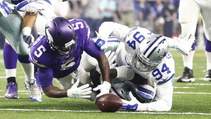 Aug 29, 2015; Arlington, TX, USA; Minnesota Vikings quarterback Teddy Bridgewater (5) fumbles the ball against Dallas Cowboys defensive end Randy Gregory (94) in the first quarter at AT&T Stadium. Mandatory Credit: Tim Heitman-USA TODAY Sports