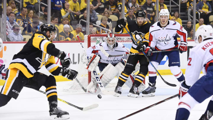 PITTSBURGH, PA – MAY 03: Pittsburgh Penguins right wing Tom Kuhnhackl (34) spins and shoots the puck as Pittsburgh Penguins center Riley Sheahan (15) sets up in front of Washington Capitals Goalie Braden Holtby (70) and Washington Capitals Defenseman John Carlson (74) defends during the second period in Game Four of the Eastern Conference Second Round in the 2018 NHL Stanley Cup Playoffs between the Washington Capitals and the Pittsburgh Penguins on May 3, 2018, at PPG Paints Arena in Pittsburgh, PA. (Photo by Jeanine Leech/Icon Sportswire via Getty Images)