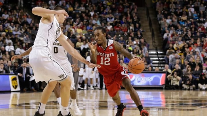 Jan 10, 2016; Winston-Salem, NC, USA; North Carolina State Wolfpack guard Anthony Barber (12) drives the ball around Wake Forest Demon Deacons forward Konstantinos Mitoglou (44) in the second half at Lawrence Joel Veterans Memorial Coliseum. Wake defeated North Carolina State 77-74. Mandatory Credit: Jeremy Brevard-USA TODAY Sports