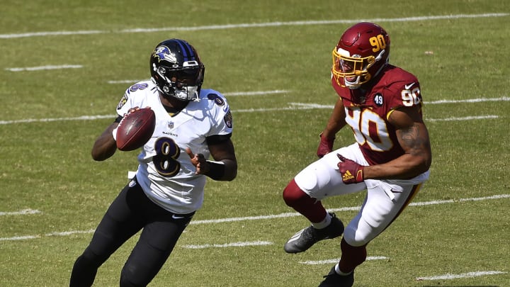 Oct 4, 2020; Landover, Maryland, USA; Baltimore Ravens quarterback Lamar Jackson (8) looks to make a pass as Washington Football Team defensive end Montez Sweat (90) chases during the second quarter at FedExField. Mandatory Credit: Brad Mills-USA TODAY Sports