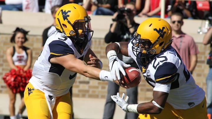 Oct 15, 2016; Lubbock, TX, USA; West Virginia Mountaineers quarterback Skyler Howard (3) hands the ball off to running back Justin Crawford (25) during the first quarter against the Texas Tech Red Raiders at Jones AT&T Stadium. Mandatory Credit: Michael C. Johnson-USA TODAY Sports