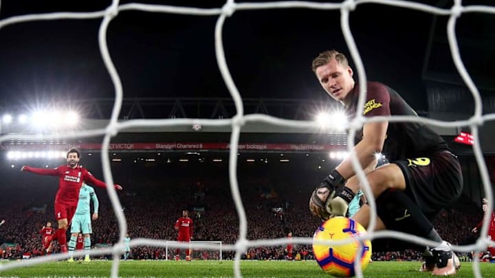 LIVERPOOL, ENGLAND - DECEMBER 29: Bernd Leno of Arsenal shows hos dejection as Mohamed Salah of Liverpool celebrates after his team mate Roberto Firmino has scored the first goal during the Premier League match between Liverpool FC and Arsenal FC at Anfield on December 29, 2018 in Liverpool, United Kingdom. (Photo by Clive Brunskill/Getty Images)