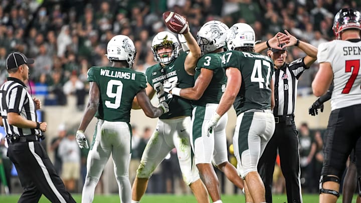 EAST LANSING, MICHIGAN – OCTOBER 02: Cal Haladay #27, Ronald Williams #9 and Xavier Henderson #3 of the Michigan State Spartans celebrate after recovering a fumble against the Western Kentucky Hilltoppers during the second quarter of the game at Spartan Stadium on October 02, 2021 in East Lansing, Michigan. (Photo by Nic Antaya/Getty Images)