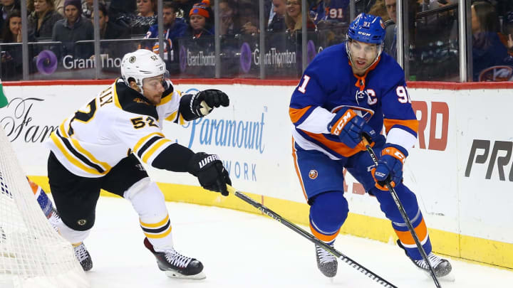 NEW YORK, NY – JANUARY 18: John Tavares #91 of the New York Islanders carries the puck around the net amid pressure from Sean Kuraly #52 of the Boston Bruins during the second period at Barclays Center on January 18, 2018 in New York City. (Photo by Mike Stobe/NHLI via Getty Images)