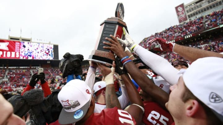 NORMAN, OK - DECEMBER 3: Members of the Oklahoma Sooners hold up the Bedlam Trophy after the game against the Oklahoma State Cowboys December 3, 2016 at Gaylord Family-Oklahoma Memorial Stadium in Norman, Oklahoma. Oklahoma defeated Oklahoma State 38-20 to become Big XII champions. (Photo by Brett Deering/Getty Images)