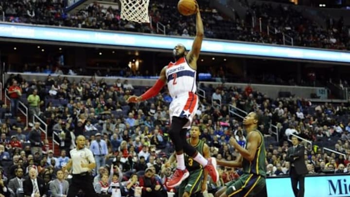 Dec 14, 2014; Washington, DC, USA; Washington Wizards guard John Wall (2) dunks the ball as Utah Jazz guard Trey Burke (3) looks on during the second half at Verizon Center. The Wizards won 93-84. Mandatory Credit: Brad Mills-USA TODAY Sports