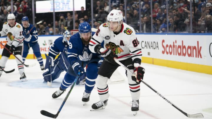 Dec 11, 2021; Toronto, Ontario, CAN; Chicago Blackhawks right wing Patrick Kane (88) battles for the puck with Toronto Maple Leafs defenseman Jake Muzzin (8) during the third period at Scotiabank Arena. Mandatory Credit: Nick Turchiaro-USA TODAY Sports