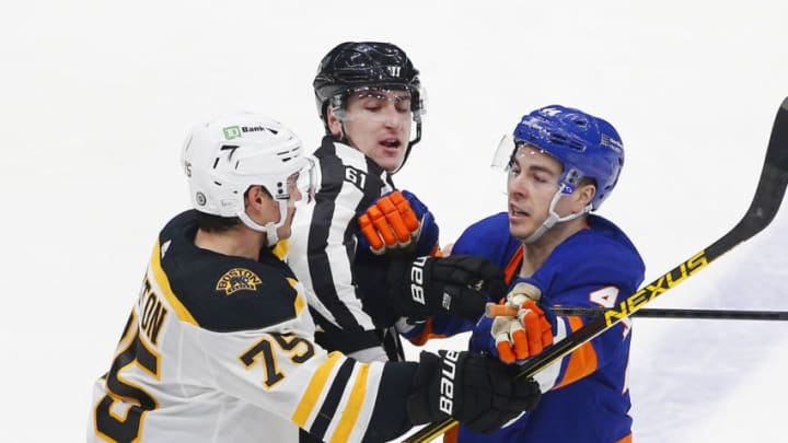 Mar 9, 2021; Uniondale, New York, USA; Boston Bruins defenseman Connor Clifton (75) and New York Islanders center Jean-Gabriel Pageau (44) are separated by linesman James Tobias (61) during the second period at Nassau Veterans Memorial Coliseum. Mandatory Credit: Andy Marlin-USA TODAY Sports