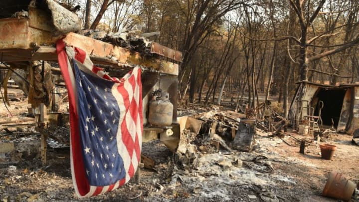 An American flag hangs at a burned out mobile home park in Paradise, California on November 18, 2018. - The family lost a home in the same spot to a fire 10 years prior. (Photo by Josh Edelson / AFP) (Photo credit should read JOSH EDELSON/AFP/Getty Images)