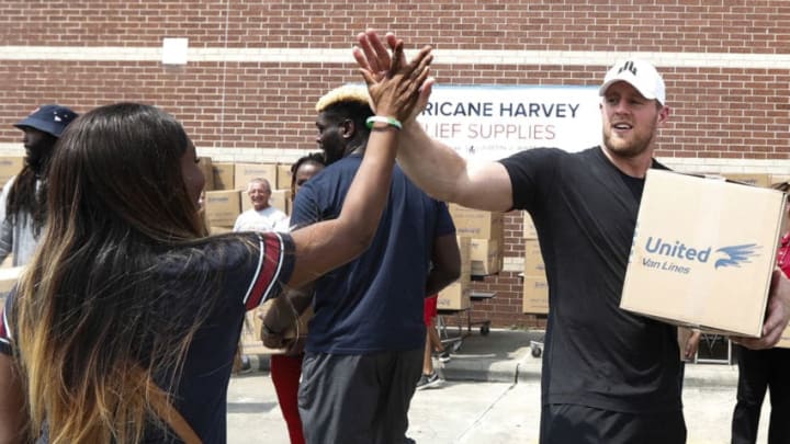 HOUSTON, TX - SEPTEMBER 3: (AFP OUT) Anna Ucheomumu high fives Houston Texans defensive end J.J. Watt after loading a car with relief supplies for people impacted by Hurricane Harvey on September 3, 2017, in Houston, Texas. J.J. Watt's Hurricane Harvey Relief Fund has raised more than $18 million to date to help those affected by the storm. (Photo by Brett Coomer - Pool/Getty Images)