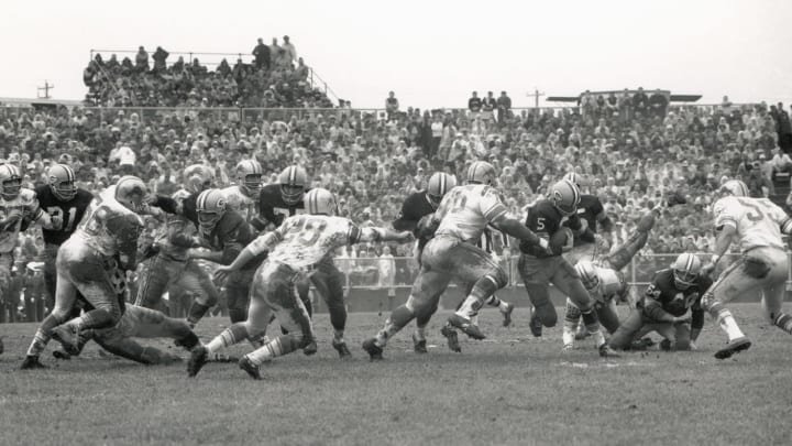 GREEN BAY, WI – OCTOBER 7: Paul Hornung #5 of the Green Bay Packers carries the ball against Carl Brettschneider #57, Joe Schmidt #56, Yale Lary #28, Roger Brown #76 and Wayne Walker #55 of the Detroit Lions during the game at the New City Stadium on October 7, 1962 in Green Bay, Wisconsin. (Photo by Robert Riger/Getty Images)