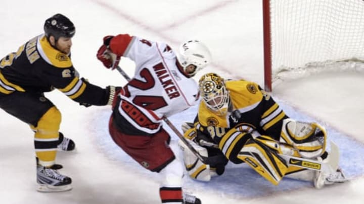 Carolina Hurricanes’ Scott Walker (24) puts the game-winning shot past Boston Bruins’ Dennis Wideman (6) and Tim Thomas (30) during overtime action in Game 7 of the NHL Eastern Conference playoffs at the TD Banknorth Garden in Boston Massachusetts, Thursday May 14, 2009. The Canes defeated the Bruins 3-2. (Photo by Chris Seward/Raleigh News & Observer/MCT via Getty Images)