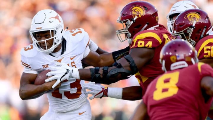 LOS ANGELES, CA - SEPTEMBER 16: Jerrod Heard #13 of the Texas Longhorns fights off Rasheem Green #94 of the USC Trojans during the first quarter at Los Angeles Memorial Coliseum on September 16, 2017 in Los Angeles, California. (Photo by Harry How/Getty Images)