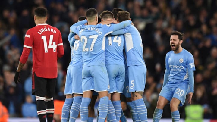Riyad Mahrez celebrates with teammates after scoring the fourth goal during the English Premier League football match between Manchester City and Manchester United at the Etihad Stadium. (Photo by OLI SCARFF/AFP via Getty Images)