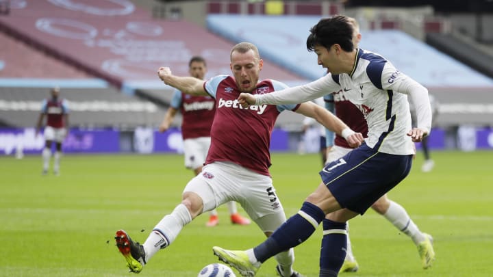 LONDON, ENGLAND – FEBRUARY 21: Son Heung-Min of Tottenham Hotspur shoots whilst under pressure from Vladimir Coufal of West Ham United during the Premier League match between West Ham United and Tottenham Hotspur at London Stadium on February 21, 2021 in London, England. Sporting stadiums around the UK remain under strict restrictions due to the Coronavirus Pandemic as Government social distancing laws prohibit fans inside venues resulting in games being played behind closed doors. (Photo by Kirsty Wigglesworth – Pool/Getty Images)