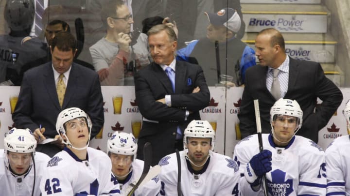 January 23, 2012; Toronto, ON, CANADA; Toronto Maple Leafs assistant coach Scott Gordon (left) and head coach Ron Wilson (center) and assistant coach Greg Cronin (right) during a break in the action during the third period against the New York Islanders at the Air Canada Centre. Toronto Maple Leafs left wing Nikolai Kulemin (41) and center Tyler Bozak (42) and center Mikhail Grabovski (84) and forward Nazem Kadri (43) and forward Joffrey Lupul (19) are on the bench. Toronto defeated New York 3-0. Mandatory Credit: John E. Sokolowski-USA TODAY Sports