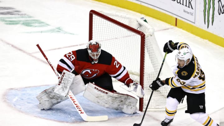 NEWARK, NEW JERSEY - JANUARY 14: Mackenzie Blackwood #29 of the New Jersey Devils stops a shot as Brad Marchand #63 of the Boston Bruins passes in the first period during the home opening game at Prudential Center on January 14, 2021 in Newark, New Jersey. (Photo by Elsa/Getty Images)