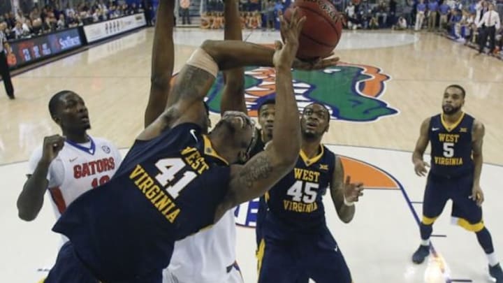 Jan 30, 2016; Gainesville, FL, USA; Florida Gators forward Dorian Finney-Smith (10) watches as West Virginia Mountaineers forward Devin Williams (41) shoots as forward Elijah Macon (45) and guard Jaysean Paige (5) wait for the rebound during the second half of a basketball game against the Florida Gators at the Stephen C. O