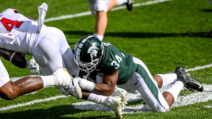 Michigan State’s Antjuan Simmons, right, tackles Rutgers’ Aaron Young during the first quarter on Saturday, Oct. 24, 2020, at Spartan Stadium in East Lansing.201024 Msu Rutgers 101a
