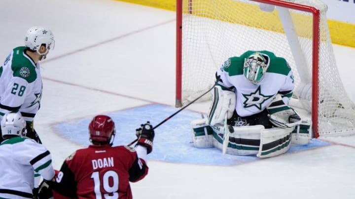 Mar 24, 2016; Glendale, AZ, USA; Dallas Stars goalie Kari Lehtonen (32) makes a save in front of Arizona Coyotes right wing Shane Doan (19) and defenseman Stephen Johns (28) in the first period at Gila River Arena. Mandatory Credit: Matt Kartozian-USA TODAY Sports