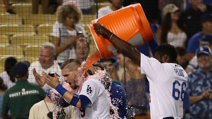 LOS ANGELES, CA - AUGUST 01: Yasmani Grandal #9 of the Los Angeles Dodgers is doused with Gatorade by teammate Yasiel Puig #66 after Grandal hit a two-run walk-off homerun over the right field fence in the tenth inning of the MLB game against the Milwaukee Brewers at Dodger Stadium on August 1, 2018 in Los Angeles, California. The Dodgers defeated the Brewers 6-4. (Photo by Victor Decolongon/Getty Images)
