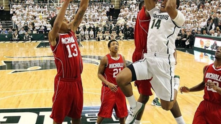 December 1, 2012; East Lansing, MI, USA; Michigan State Spartans guard Gary Harris (14) drives to the basket against Nicholls State Colonels forward Travis Julien (13) during the second half at Jack Breslin Students Events Center. MSU won 84-39. Mandatory Credit: Mike Carter-USA TODAY Sports