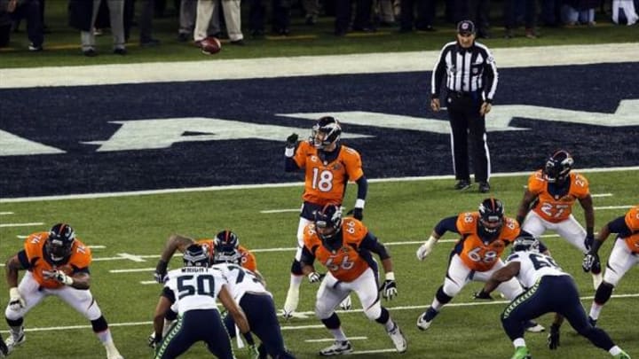 Feb 2, 2014; East Rutherford, NJ, USA; The snap goes over the head of Denver Broncos quarterback Peyton Manning (18) during the first quarter in Super Bowl XLVIII against the Seattle Seahawks at MetLife Stadium. Mandatory Credit: Noah K. Murray-USA TODAY Sports