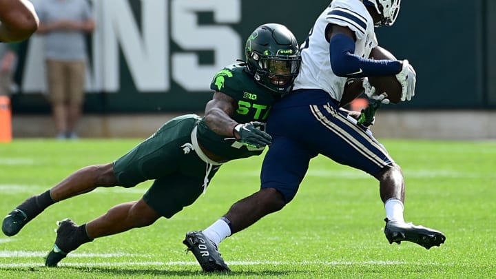 Sep 10, 2022; East Lansing, Michigan, USA; Michigan State Spartans safety Angelo Grose (15) tackles Akron Zips wide receiver Shocky Jacques-Louis (18) in the first quarter. Mandatory Credit: Dale Young-USA TODAY Sports