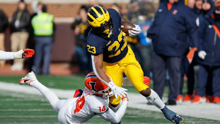 Nov 19, 2022; Ann Arbor, Michigan, USA; Michigan Wolverines running back C.J. Stokes (23) is tackled by Illinois Fighting Illini defensive back Xavier Scott (14) in the first half at Michigan Stadium. Mandatory Credit: Rick Osentoski-USA TODAY Sports