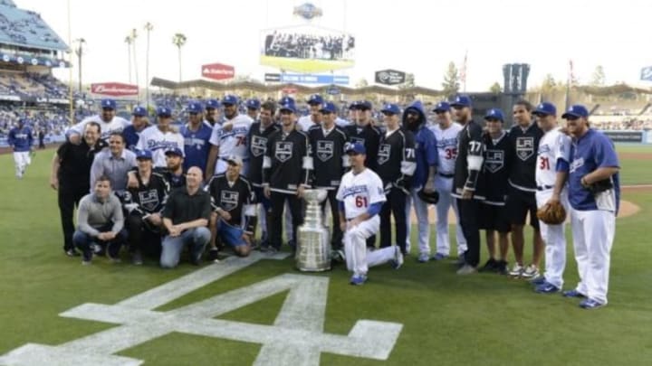 Jun 17, 2014; Los Angeles, CA, USA; The Los Angeles Kings and the Los Angeles Dodgers stand with the Stanley Cup before the game between the Colorado Rockies and the Los Angeles Dodgers at Dodger Stadium. Mandatory Credit: Richard Mackson-USA TODAY Sports