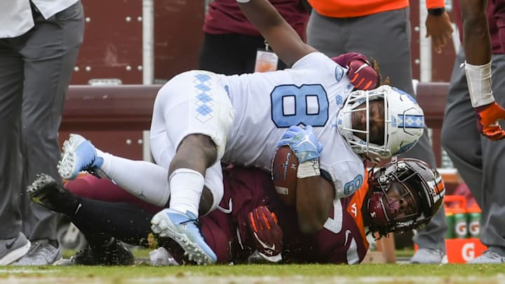 BLACKSBURG, VA – OCTOBER 19: Running back Michael Carter #8 of the North Carolina Tar Heels is tackled by defensive back Devon Hunter #25 of the Virginia Tech Hokies in the first half at Lane Stadium on October 19, 2019 in Blacksburg, Virginia. (Photo by Michael Shroyer/Getty Images).