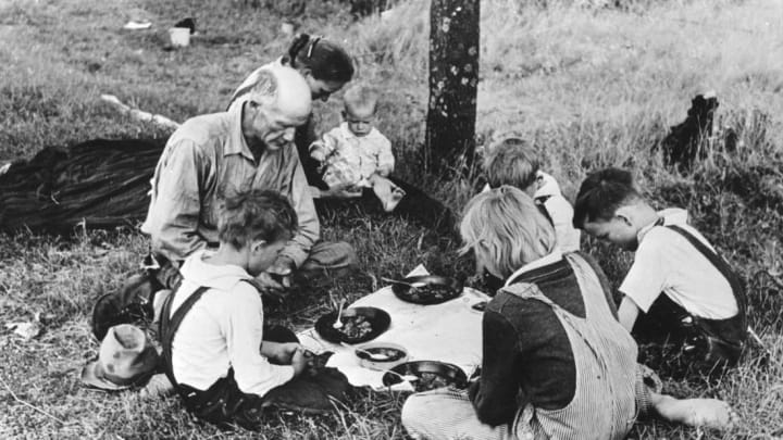 A family eating dinner by the roadside circa 1930.