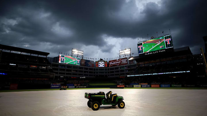 ARLINGTON, TX - JULY 05: The grounds crew finishes covering the field during a rain delay prior to the Texas Rangers taking on the Boston Red Sox at Globe Life Park in Arlington on July 5, 2017 in Arlington, Texas. (Photo by Tom Pennington/Getty Images)