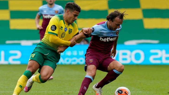 Norwich City's English defender Max Aarons (L) fights for the ball with West Ham United's English midfielder Mark Noble during the English Premier League football match between Norwich City and West Ham United at Carrow Road in Norwich, eastern England on July 11, 2020. (Photo by Tim Keeton / POOL / AFP) / RESTRICTED TO EDITORIAL USE. No use with unauthorized audio, video, data, fixture lists, club/league logos or 'live' services. Online in-match use limited to 120 images. An additional 40 images may be used in extra time. No video emulation. Social media in-match use limited to 120 images. An additional 40 images may be used in extra time. No use in betting publications, games or single club/league/player publications. / (Photo by TIM KEETON/POOL/AFP via Getty Images)