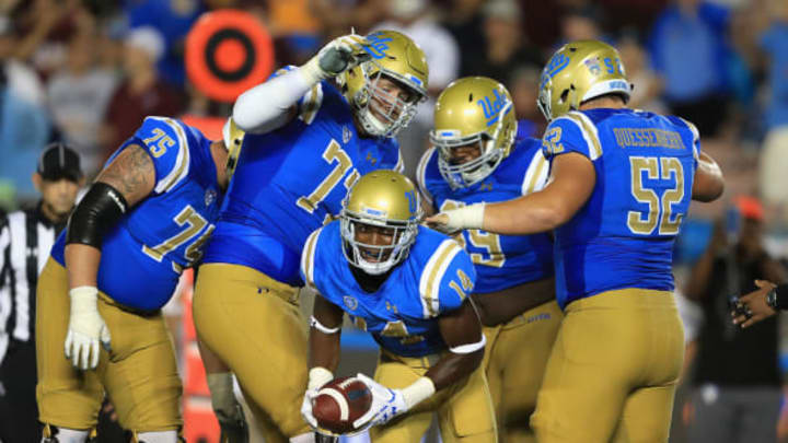 PASADENA, CA – SEPTEMBER 03: Theo Howard #14 reacts after a touchdown on a pass play as Scott Quessenberry #52, Kolton Miller #77, and Andre James #75 of the UCLA Bruins react during the second half of a game against the Texas A&M Aggies at the Rose Bowl on September 3, 2017 in Pasadena, California. (Photo by Sean M. Haffey/Getty Images)